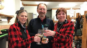 2 women and a man clinking wine glasses