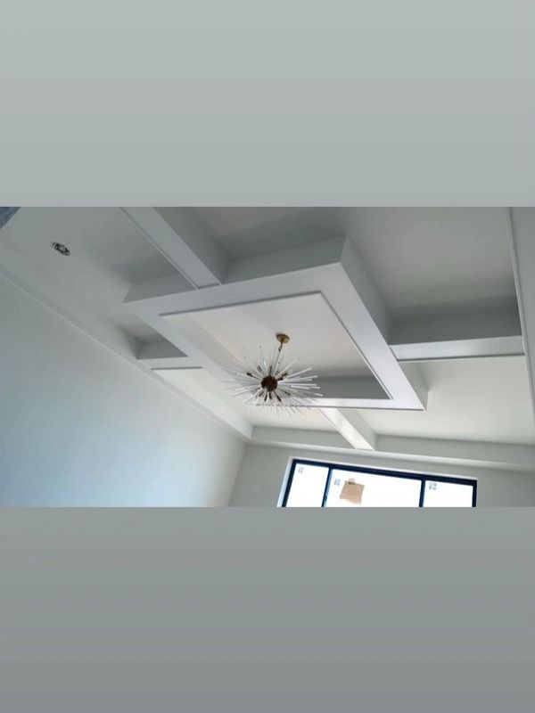 Modern ceiling design with geometric beams and a stylish chandelier.