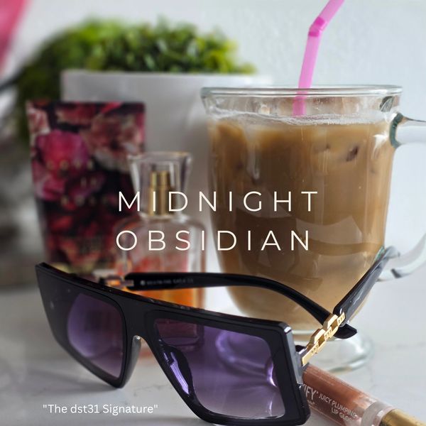 Sleek black sunglasses with iced coffee and beauty products in the background.