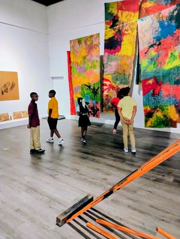 Children exploring colorful modern art in a gallery.