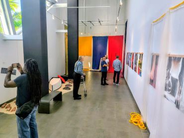 People viewing art in a gallery with colorful panels.