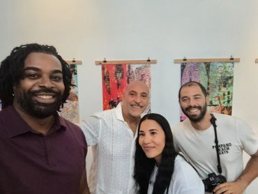 Four smiling people posing in an art gallery.