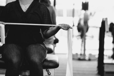 Person exercising with a resistance band in a gym.