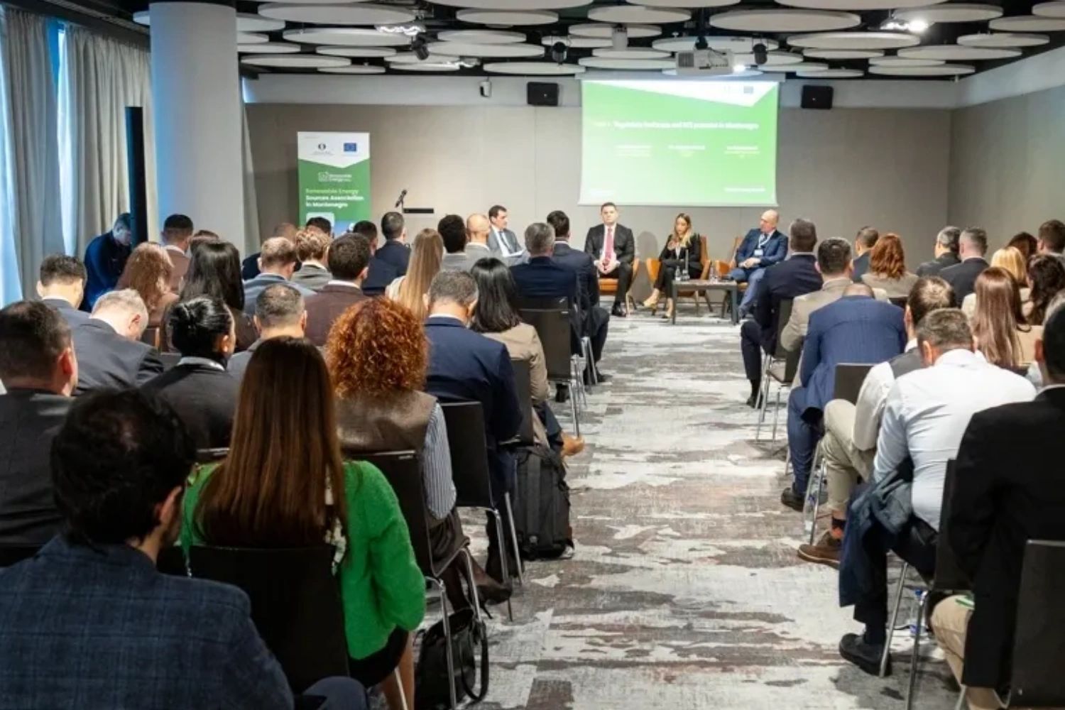 A professional panel discussion in a conference room with attentive audience.