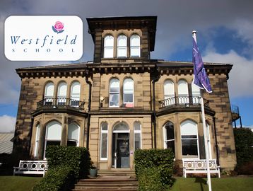 Historic building with Westfield School signage and flag.