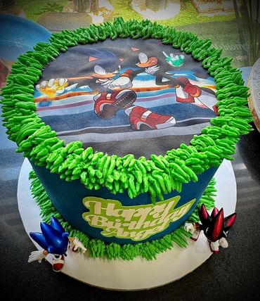 A Sonic-themed birthday cake with green icing and figurines.