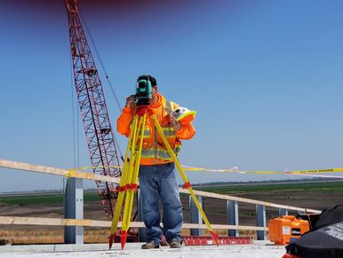 topógrafo realizando mediciones con estación total, en una obra de construcción
