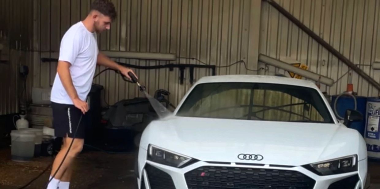 A man washing a white Audi car.