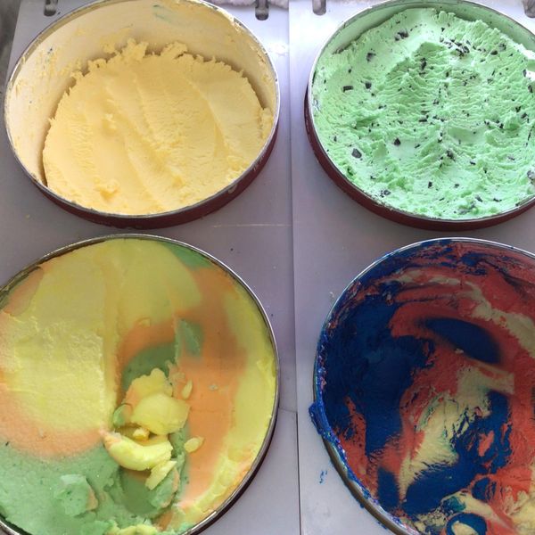 Four containers of colorful ice cream with different flavors and textures.