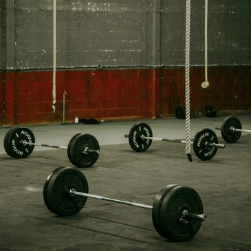 Barbells and ropes in a gym setting.