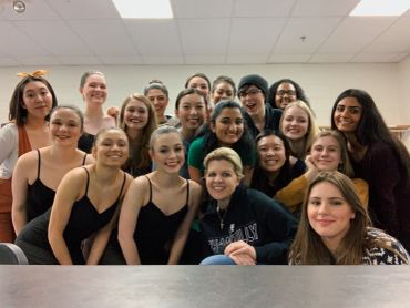 Group photo of smiling young women indoors.