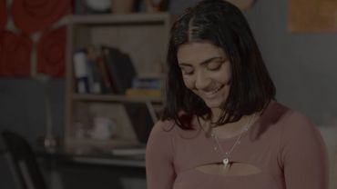 Smiling woman looking down indoors.