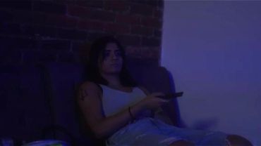 Woman sitting on a couch with a remote in hand.