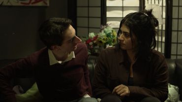Two people engaged in a serious conversation indoors.