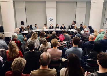 A panel discussion with an attentive audience in a modern room.