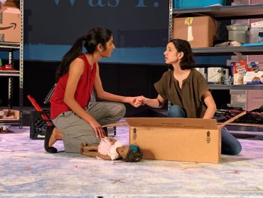 Two women holding hands in a theatrical setting.