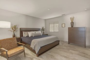 Modern bedroom with wooden furniture and neutral tones.