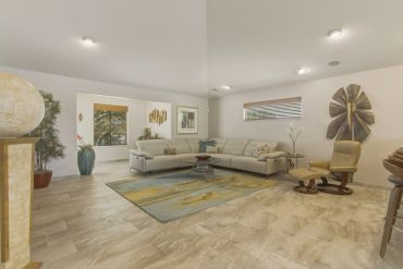 Spacious living room with modern furniture and neutral tones.