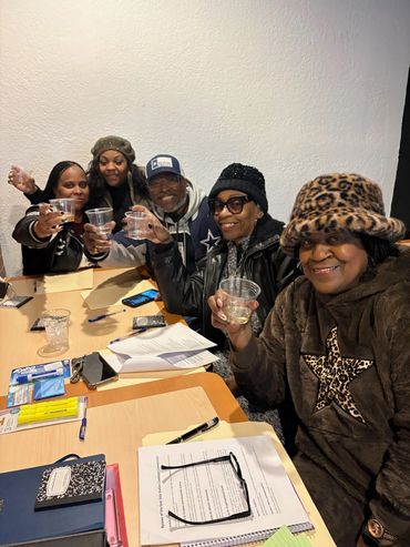 Group of friends raising glasses around a table with papers and notebooks.