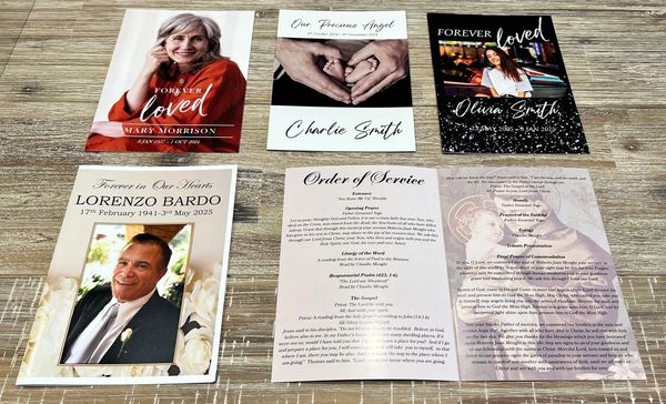 Memorial cards and funeral order of service laid out on a wooden surface.