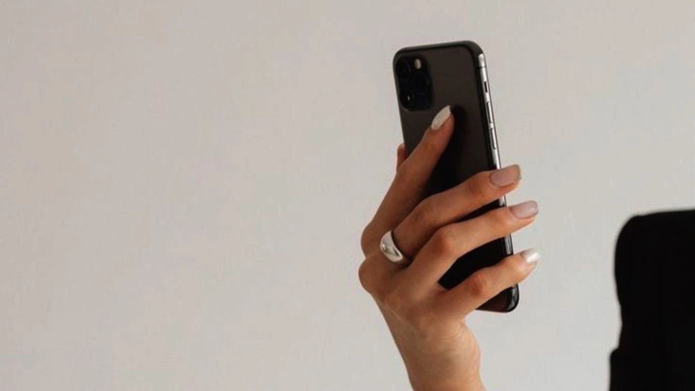 a person in a black suit holding a cell phone