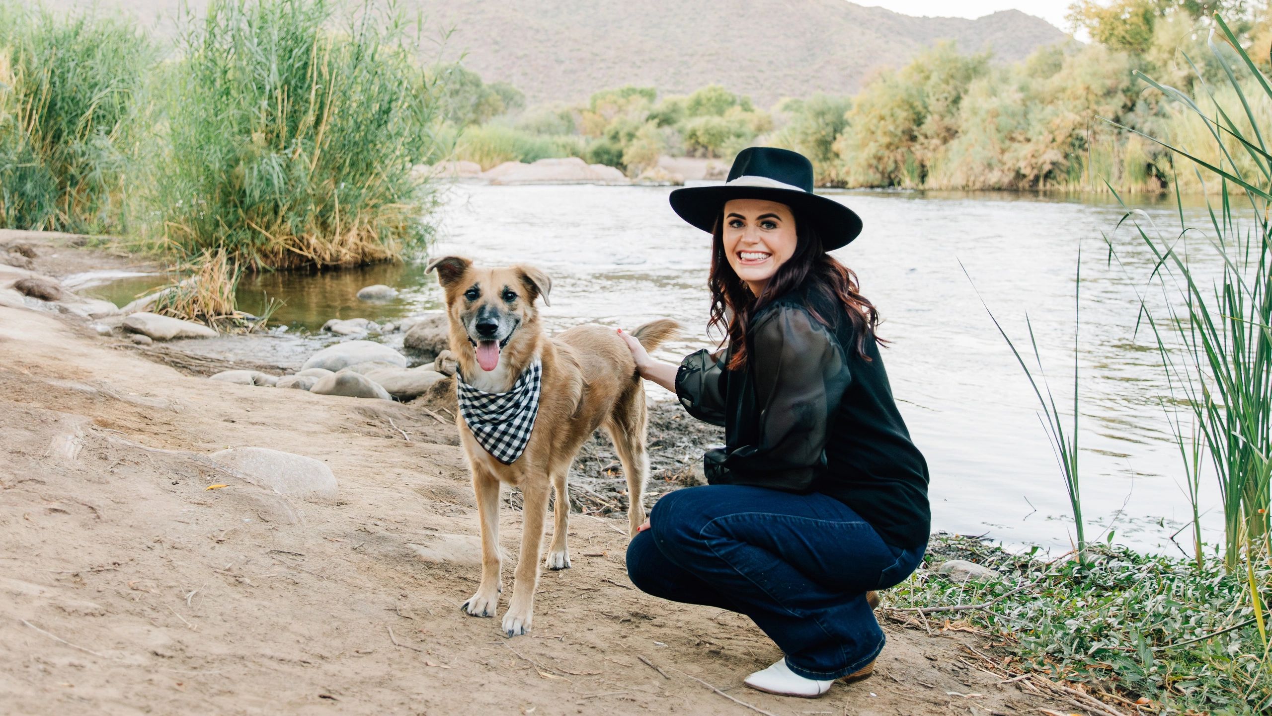 CEO, Chelsea kneeling next to a river with her dog, CBO, Austin