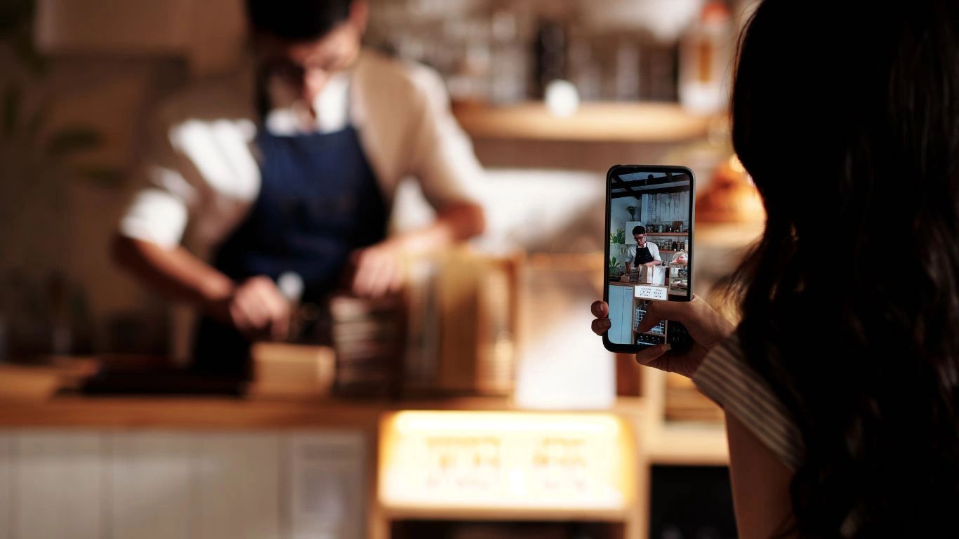 a person taking a photo of a person in a restaurant