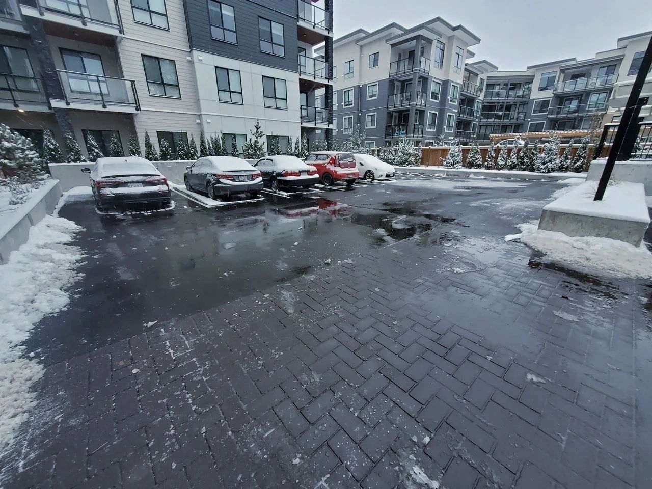 Condo building in Vancouver with a plowed parking area and salted