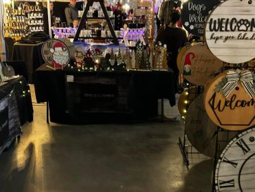 A cozy indoor market booth displaying handmade wooden signs and crafts.
