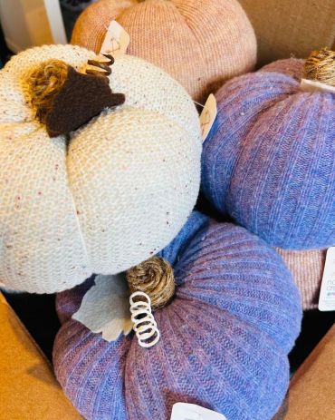 Handcrafted knit pumpkins in pastel colors for autumn decor.