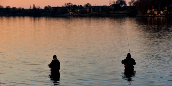 Two men wader fishing at sunset