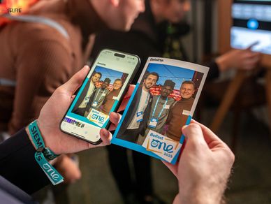 2 hands holding a cell phone and printed photo of Photo Booth images
