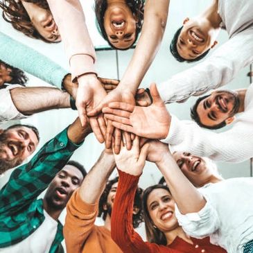 Group of diverse friends joining hands in unity and happiness.