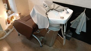 Salon shampoo station with reclining chair and sink.