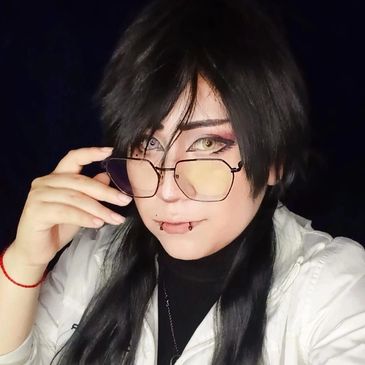 Person with black hair and glasses posing stylishly.