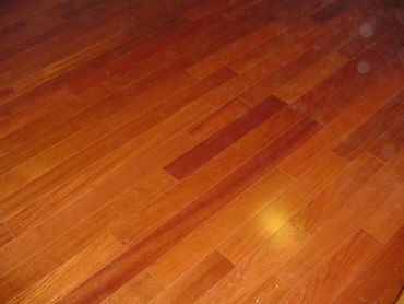 Polished wooden floor with varying shades of brown planks.