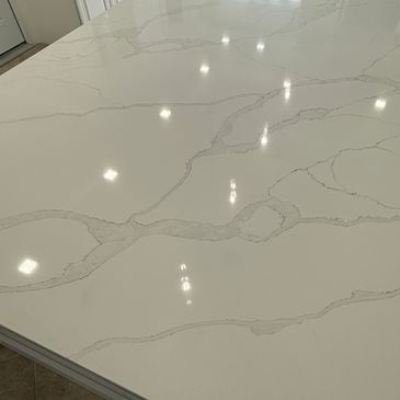 Polished white marble countertop with veins.