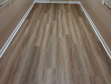 Newly installed wood-patterned vinyl flooring in a small room.