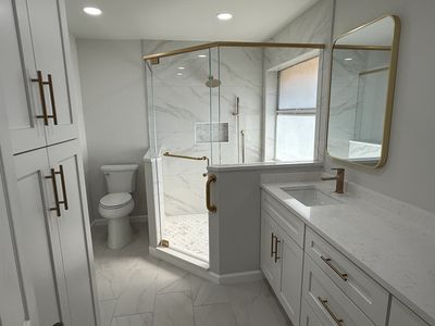 Modern bathroom with glass shower and white cabinetry.