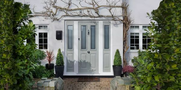 A composite door with side glazing panels in a white house with georgian bar double glazed windows