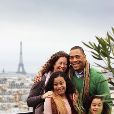 Happy family posing with the Eiffel Tower in the background.