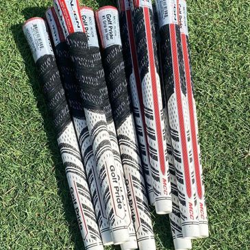 Golf club grips arranged on grass, labeled Golf Pride.