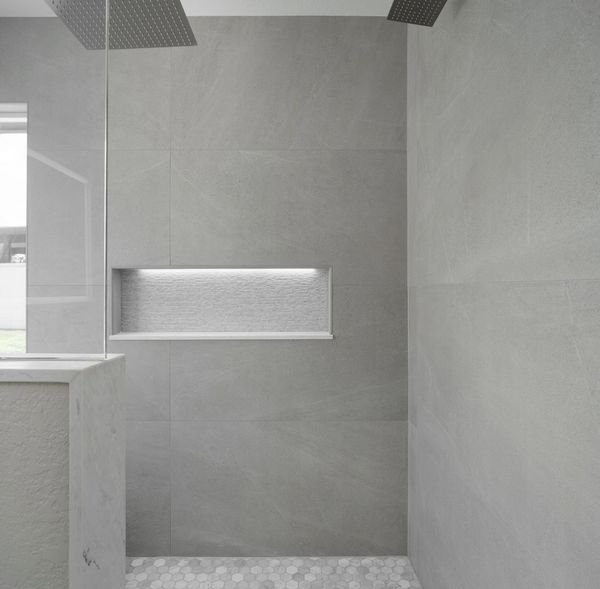 Grey large format tile in shower. Light up niche in shower. Walk in shower with rain heads. 