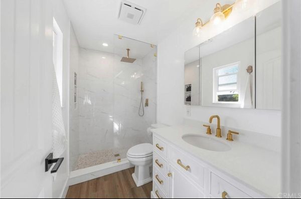 Large format shower tiled by Justice Renovations. Gold fixtures in master bathroom. White and gold