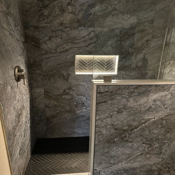 blue large format tiled shower by Justice Renovations. Light up niche in shower. 
