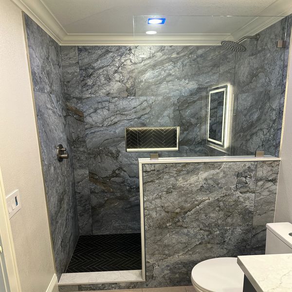 Blue large format tile in guest bathroom. Crown molding by Justice Renovations. 