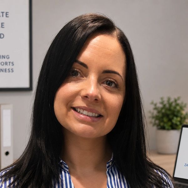 Smiling woman with long dark hair in a professional setting.