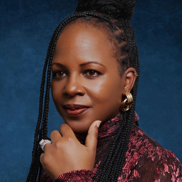 Confident woman with braided hair and gold earrings.