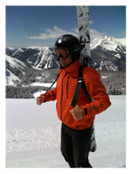 A man wearing an orange jacket carrying 