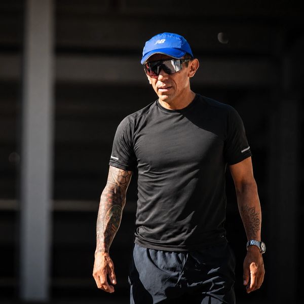 Hombre con gorra azul y camiseta negra al aire libre.